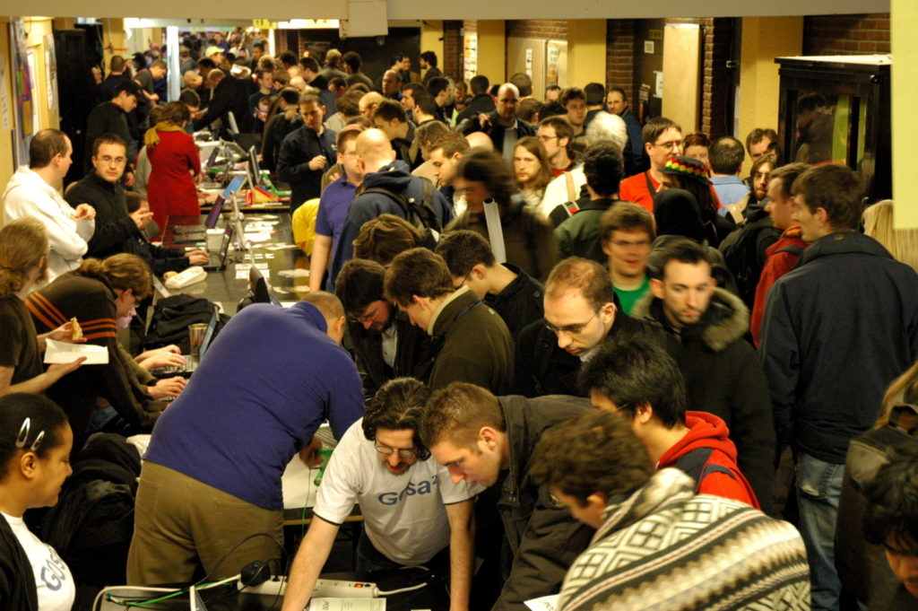 People at the Fedora booth looking at something. 